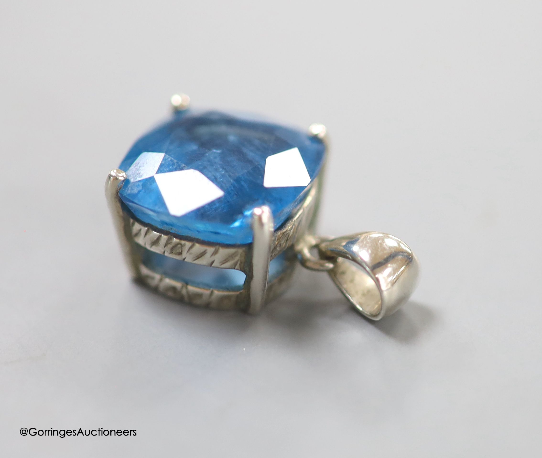 A white metal mounted square cushion cut blue topaz pendant